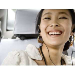  Young Chinese Woman in a Taxi Listens to Music on Her 