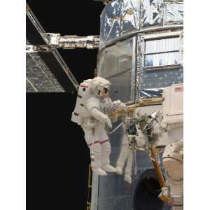  Astronauts Working on the Hubble Space Telescope During a 