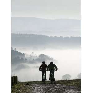  Two Mountain Bikes Climbing up Hill, Silhouetted Against 